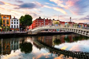 Night view of famous illuminated Ha Penny Bridge in Dublin, Ireland at sunset