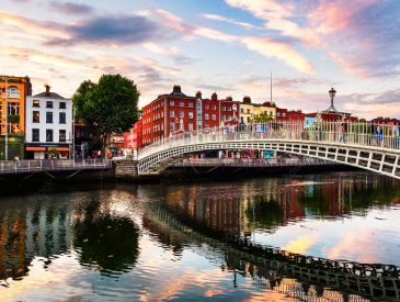 Night view of famous illuminated Ha Penny Bridge in Dublin, Ireland at sunset